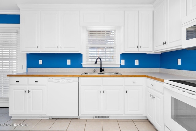 kitchen featuring sink, white cabinetry, white appliances, ornamental molding, and light tile patterned floors