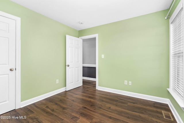 unfurnished bedroom with dark wood-type flooring