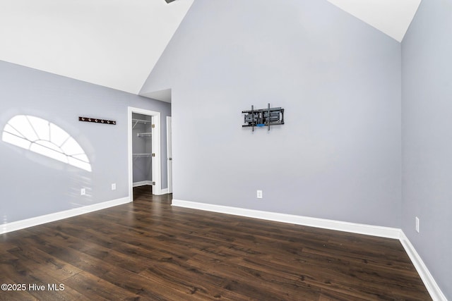 empty room featuring high vaulted ceiling and dark hardwood / wood-style flooring