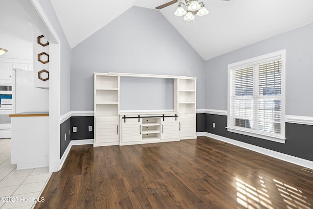 unfurnished living room with hardwood / wood-style flooring, ceiling fan, and vaulted ceiling