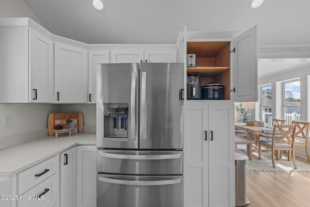 kitchen with white cabinetry, stainless steel fridge, and light hardwood / wood-style floors