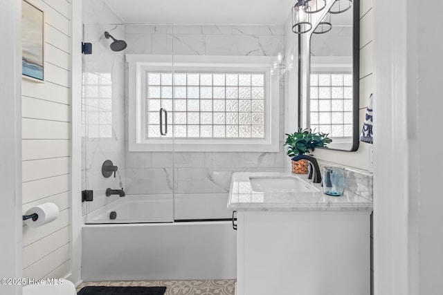 bathroom featuring tiled shower / bath, vanity, and a wealth of natural light