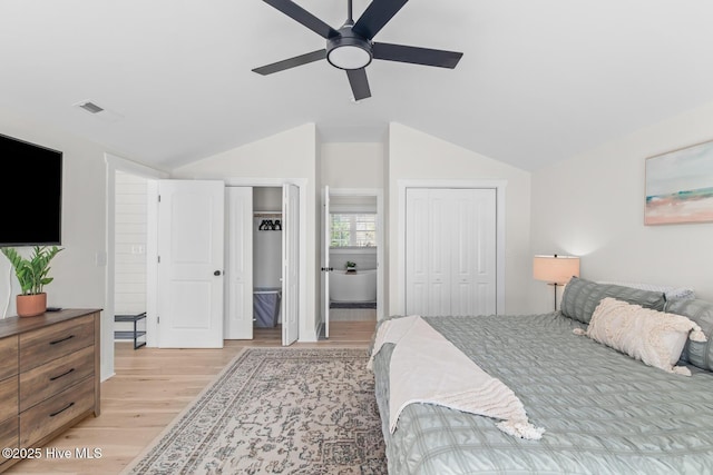 bedroom featuring lofted ceiling, multiple closets, light hardwood / wood-style flooring, and ceiling fan