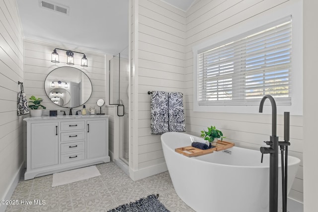 bathroom featuring vanity, wooden walls, tile patterned floors, and plus walk in shower