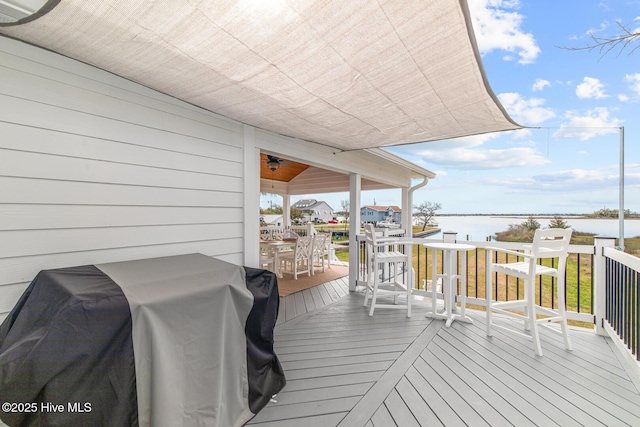 wooden terrace featuring a water view and grilling area