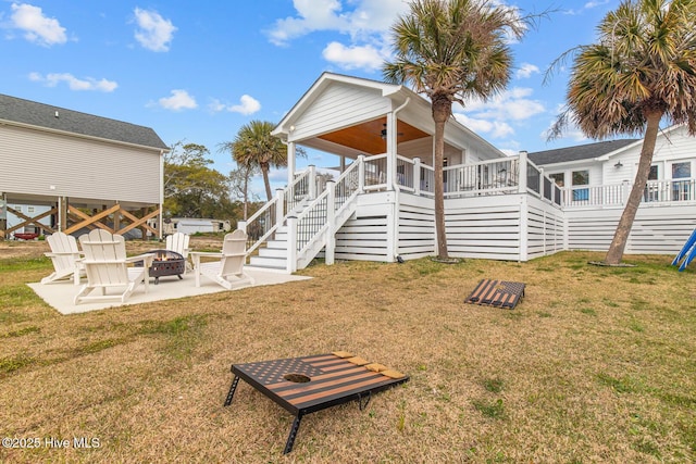 rear view of property with a lawn, a patio, ceiling fan, and an outdoor fire pit