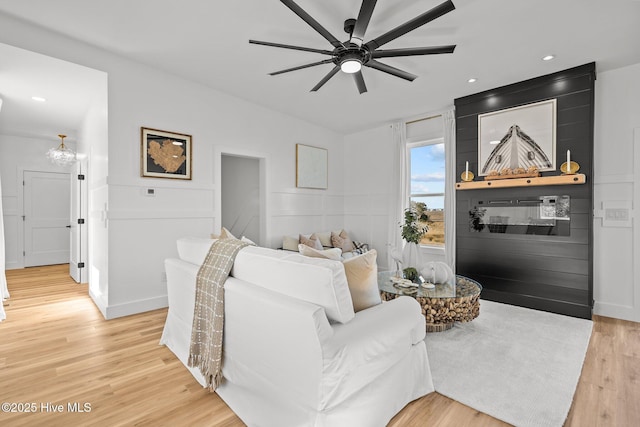 living room with light hardwood / wood-style floors and ceiling fan