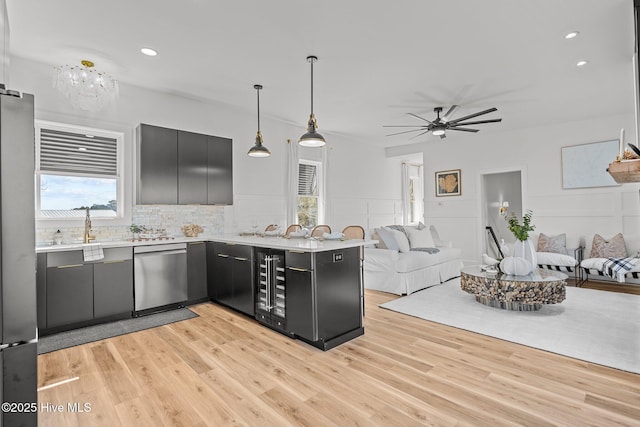 kitchen with pendant lighting, wine cooler, light hardwood / wood-style floors, kitchen peninsula, and stainless steel appliances