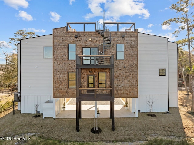 rear view of property featuring a balcony and a yard