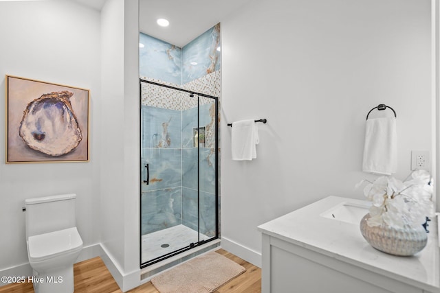 bathroom featuring a shower with door, wood-type flooring, vanity, and toilet