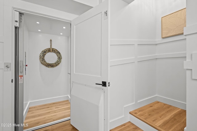 bathroom featuring hardwood / wood-style floors and elevator