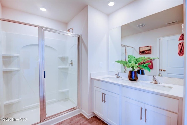 bathroom featuring a shower with door, vanity, and hardwood / wood-style floors