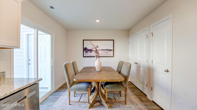 dining room with baseboards, wood finished floors, visible vents, and recessed lighting