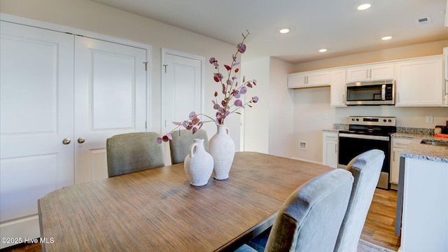 dining area featuring recessed lighting, visible vents, and light wood finished floors