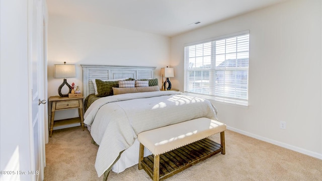 bedroom with baseboards and light colored carpet