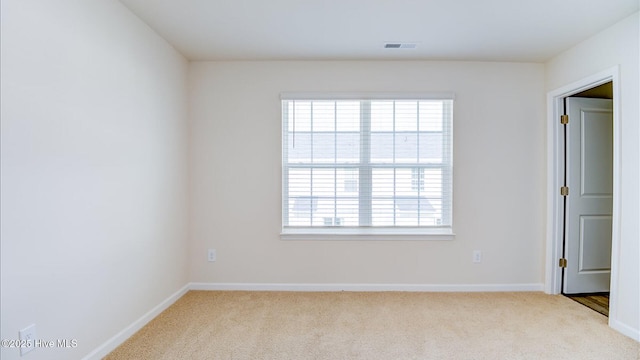 empty room featuring baseboards, visible vents, and carpet flooring