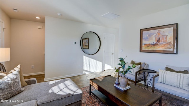 living area with baseboards and wood finished floors