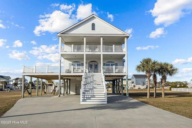 beach home with a porch, a balcony, and a carport