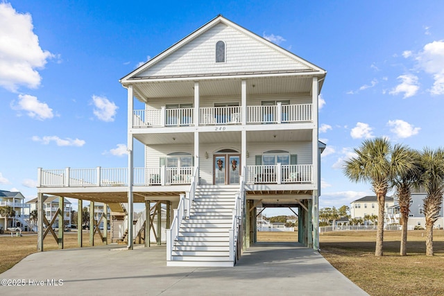 coastal home with a porch, a carport, and a balcony