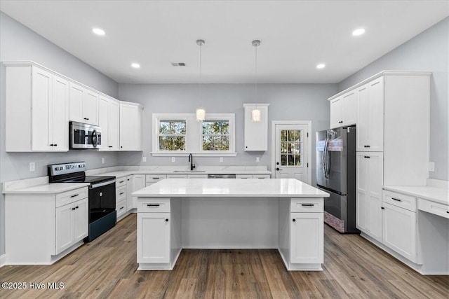 kitchen featuring white cabinetry, a kitchen island, dark hardwood / wood-style floors, and appliances with stainless steel finishes