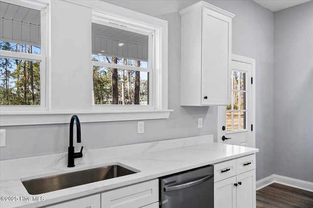 kitchen with sink, stainless steel dishwasher, white cabinets, and light stone countertops