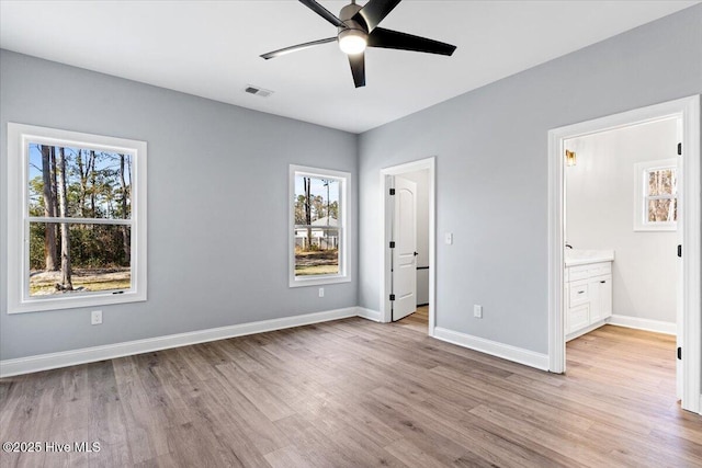 unfurnished bedroom featuring ceiling fan, light wood-type flooring, and ensuite bath