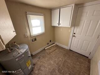 laundry room featuring water heater and cabinets