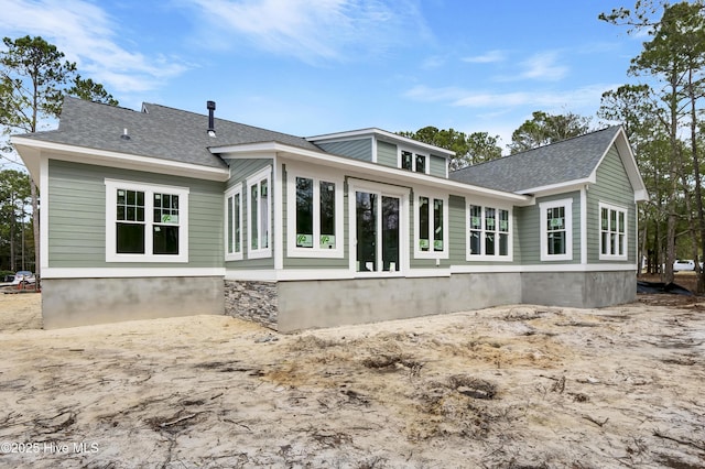 rear view of house with a shingled roof