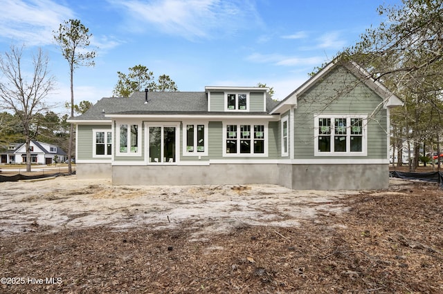 rear view of house with roof with shingles