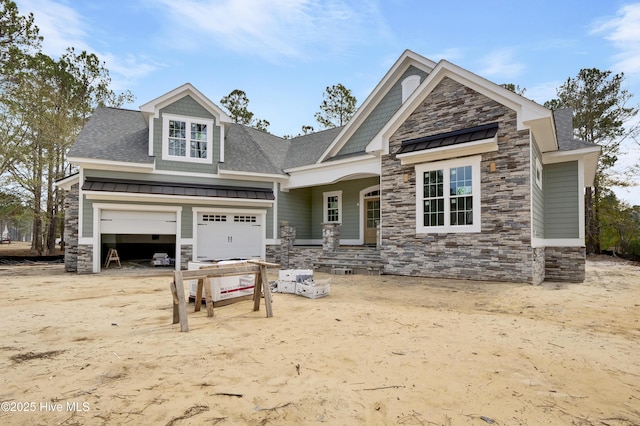 craftsman-style home featuring roof with shingles, metal roof, stone siding, an attached garage, and a standing seam roof