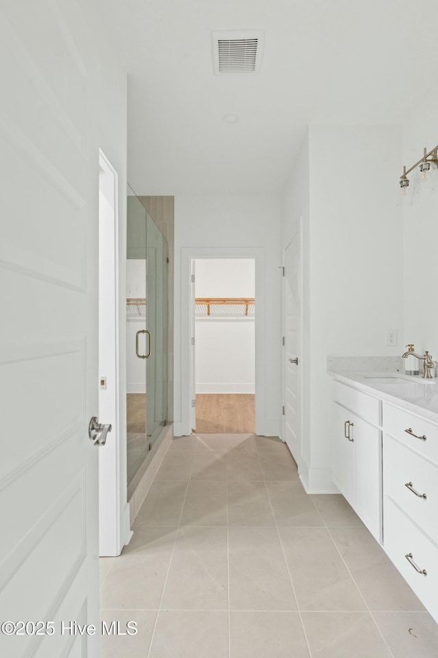 bathroom with vanity, tile patterned flooring, and walk in shower