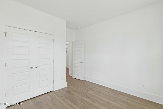 unfurnished bedroom with a closet and light hardwood / wood-style floors