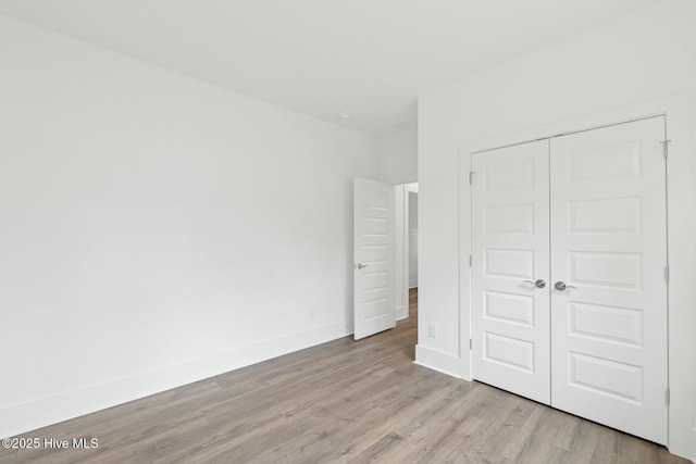 unfurnished bedroom featuring a closet and light hardwood / wood-style flooring