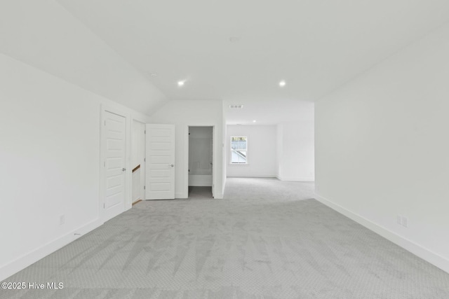 carpeted spare room featuring lofted ceiling