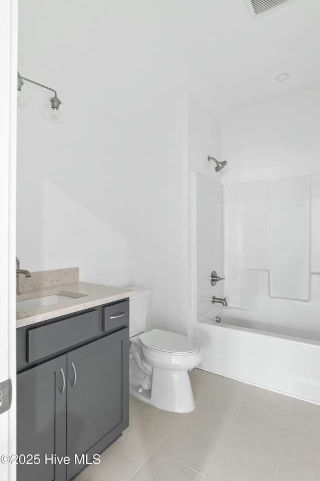 full bathroom featuring toilet, vanity, tile patterned floors, and bathtub / shower combination