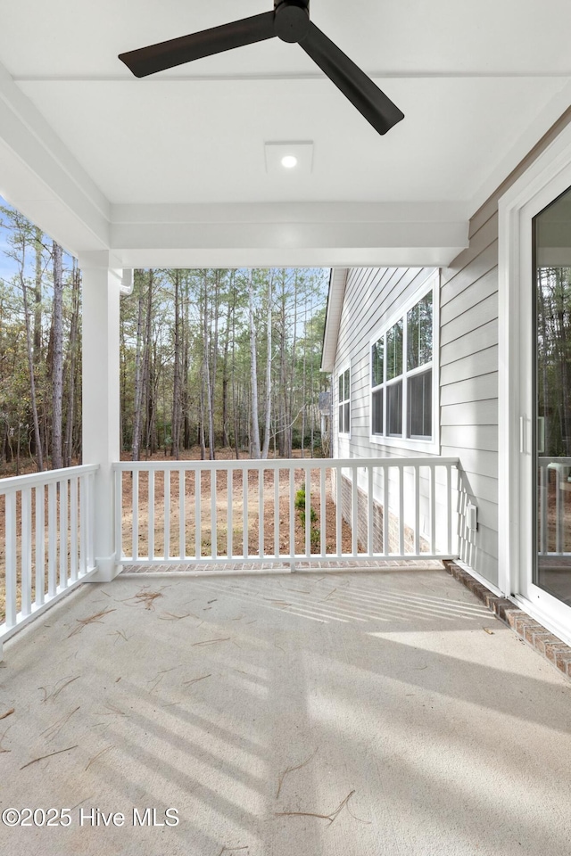 unfurnished sunroom featuring ceiling fan