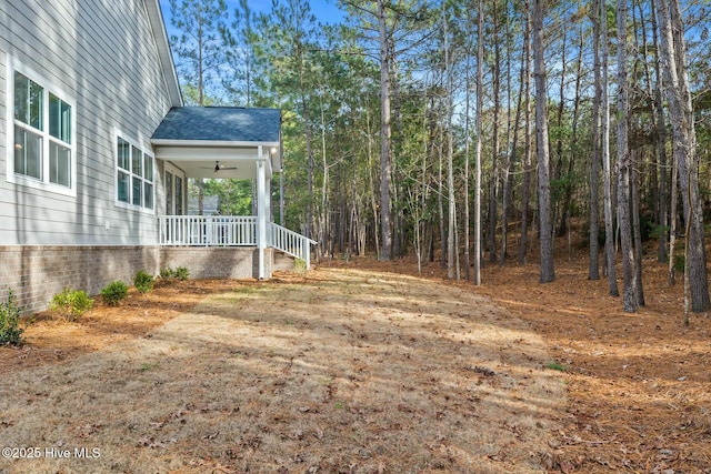 view of yard featuring covered porch and ceiling fan