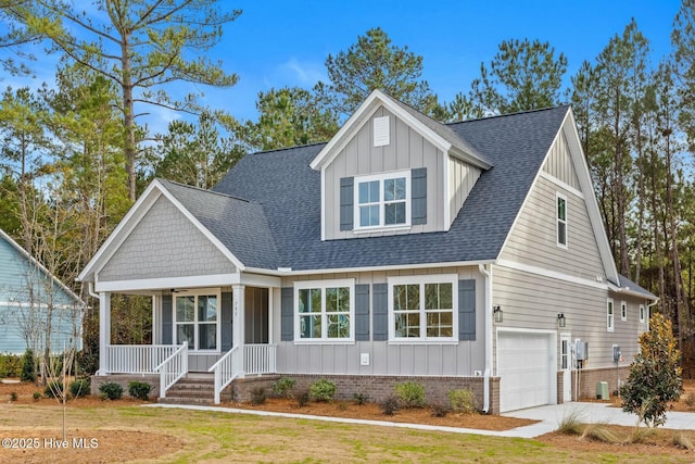 view of front of property featuring covered porch, a front lawn, and a garage