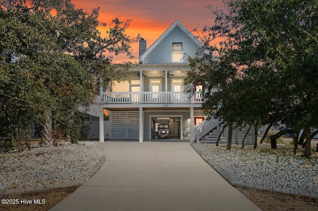 view of front of house with ceiling fan, a garage, and a porch