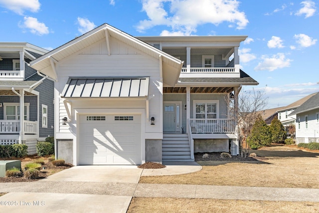 view of front facade with covered porch, a standing seam roof, metal roof, a garage, and driveway