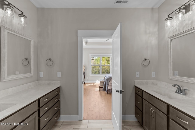 full bath with baseboards, visible vents, connected bathroom, and vanity