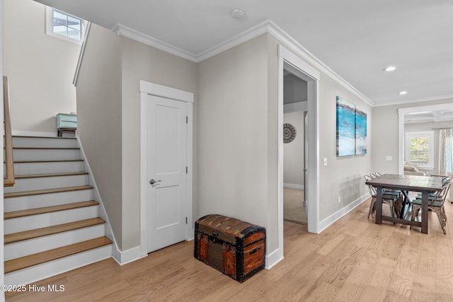 stairs featuring ornamental molding, wood finished floors, and baseboards