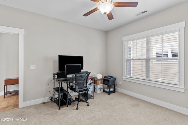 carpeted office space with a ceiling fan, visible vents, and baseboards