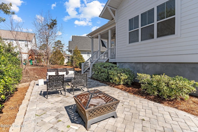 view of patio / terrace featuring an outdoor fire pit, stairs, outdoor dining area, and a playground