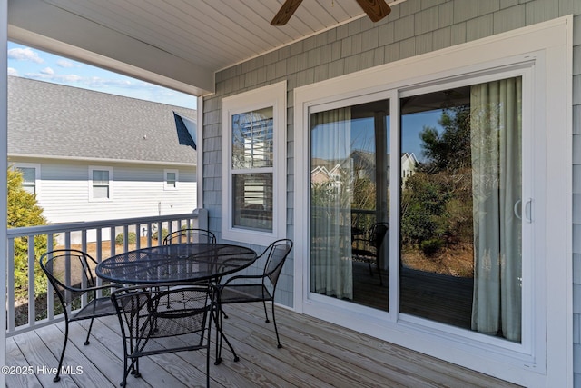 wooden deck with a ceiling fan and outdoor dining space