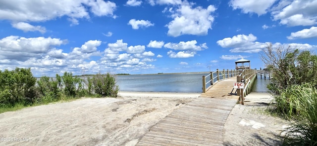 view of dock featuring a view of the beach and a water view