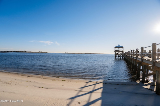 dock area with a water view and a view of the beach