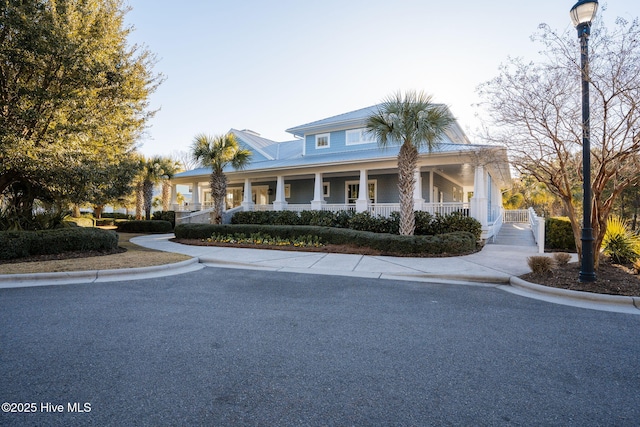 country-style home with a porch and metal roof