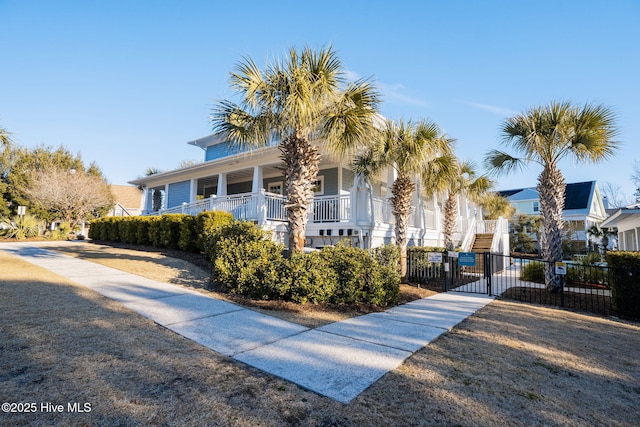 view of front of house featuring a gate, covered porch, and fence