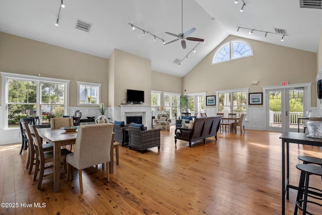 dining area with track lighting, ceiling fan, visible vents, and a fireplace